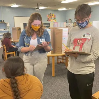 Leala Oullette and Chris Bove assist in judging science fair projects at a local elementary school